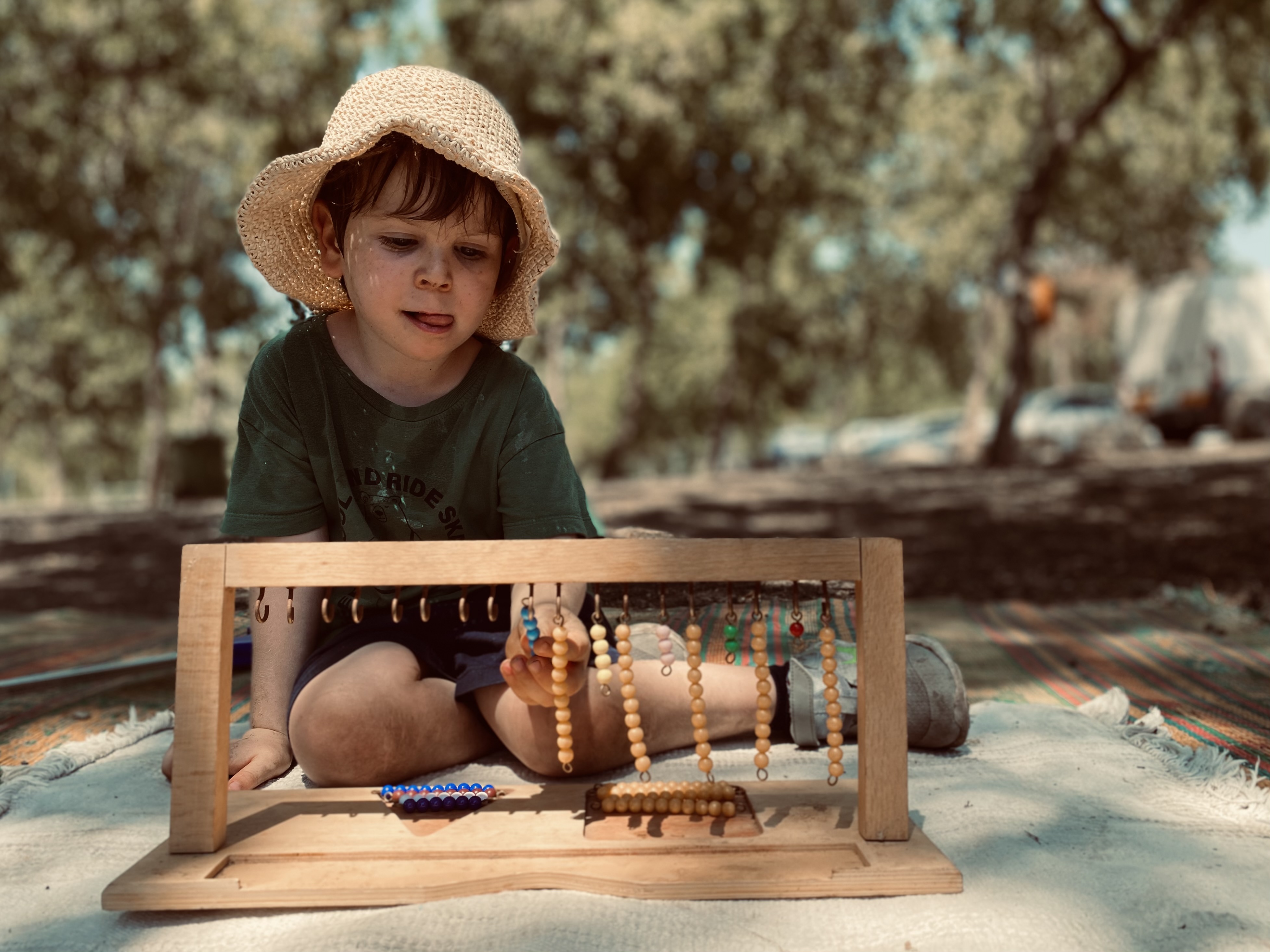 ילדה עם עזרים מונטסוריים בטבע